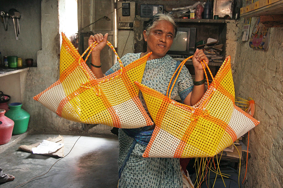 Les femmes du bidonville fabriquent des sacs en plastique tressés, Madras, INDE- 03/03/2008.